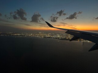 Airplane window view of sunset overlooking Doha, Qatar