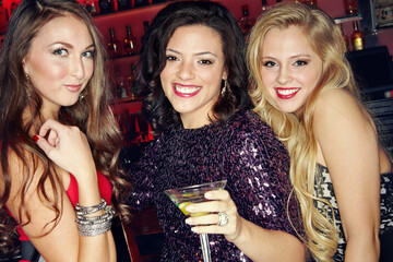 Happy women, portrait and night club with drink for party, disco or social bonding at indoor bar....