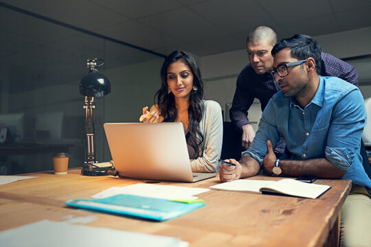 Night, laptop and meeting with business people in office for teamwork, planning and media agency. Collaboration, creative advice and production editor with employees for discussion and intern