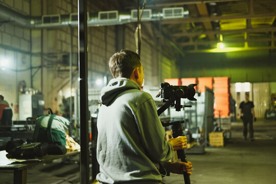 Filmmaker preparing to shoot in a spacious industrial setting