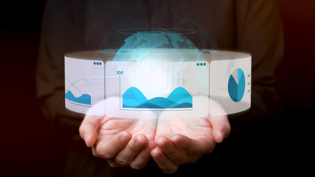 A person holds a futuristic digital interface displaying data analytics, including graphs, charts, and a holographic globe, symbolizing technology and global insights. - Powered by Adobe