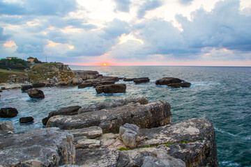 Dramatic sunset over a rocky coastline. A breathtaking coastal scene at sunset.