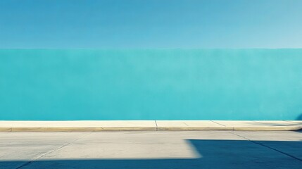Vibrant Blue Wall with Clear Sky and Sunlit Pavement in Urban Setting