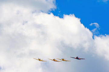 Airplanes flying in formation among the clouds in the sky