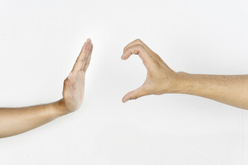 A hand makes a 'stop' gesture toward another hand forming a half-heart shape on white background.