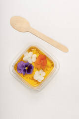 A selection of gourmet desserts decorated with edible flowers, presented in a minimalist style on a white background.