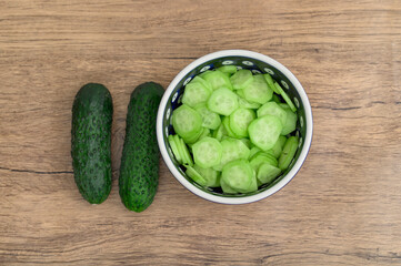 Małe zielone ogórki porkojone w plasterki na mizerię do obiadu z bliska 
