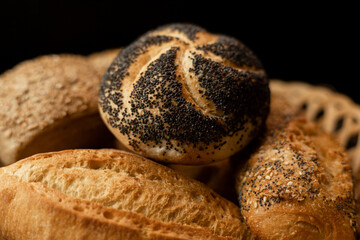 A bun with poppy seeds is in a basket with bread. Baking with moko.Poppy filling
