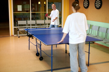 Two people playing table tennis. Man and woman compete in ping pong club