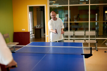 Two people playing table tennis. Man and woman compete in ping pong club