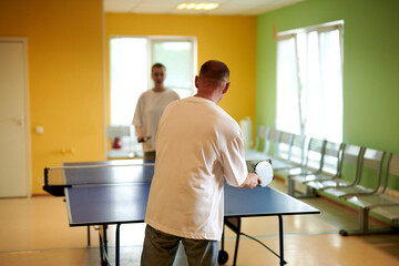 Two people playing table tennis. Man and woman compete in ping pong club
