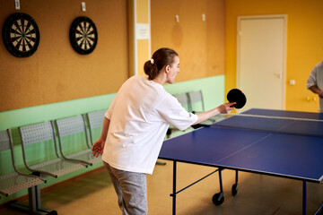 Two people playing table tennis. Man and woman compete in ping pong club