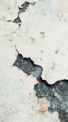 Fototapeta premium A close-up view of cracked white plaster, revealing a textured surface with dark underlayers, showcasing deterioration and wear.