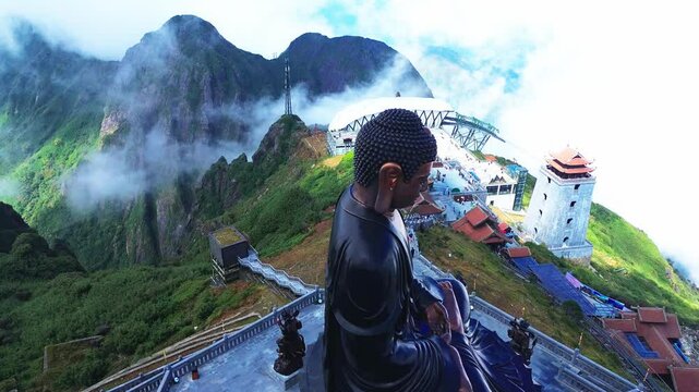 Aerial drone footage of a giant Buddha along the sacred temple on the peak of the mountain in Sapa, Vietnam.