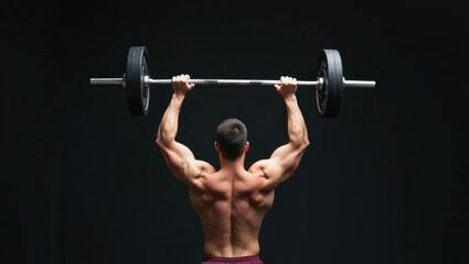 Overhead Press. Man is lifting barbell in dark with his back