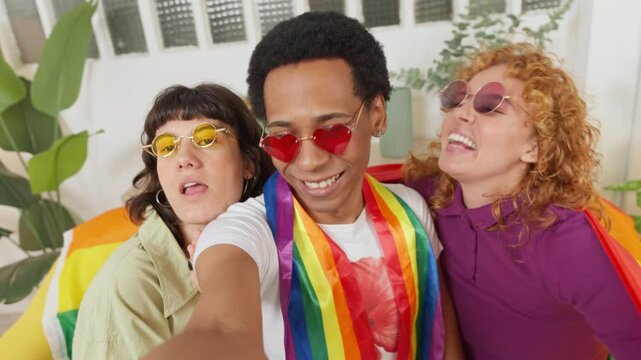 Friends posing with rainbow flag celebrating pride
