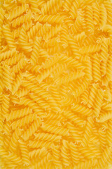Obraz premium A close-up, top-down shot of uncooked fusilli pasta, showcasing its spiral shape and golden color