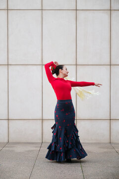 Woman dancing flamenco in front of a modern white wall