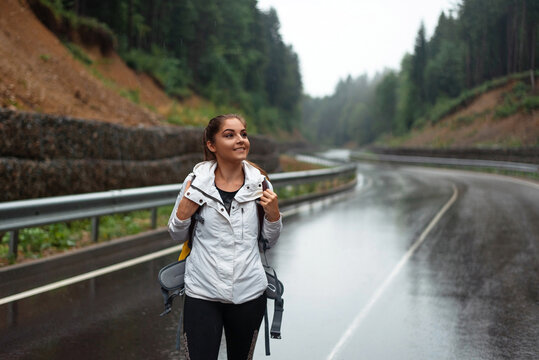 Charming woman hiking alone among mountains with big backpack
