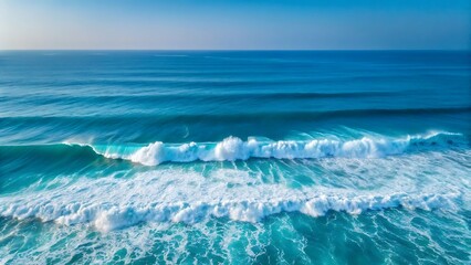 Obraz premium Clear blue ocean waves crashing on the sandy beach under a bright sky