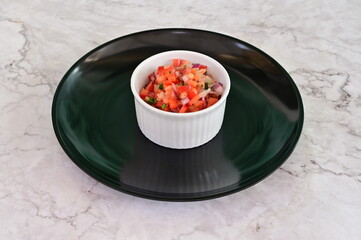 A small bowl of food with a red and green color
