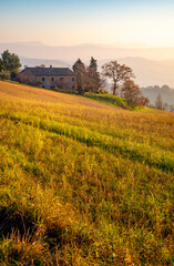 A house on the road between Mondaino and Belvedere Foglience, on the border between Emilia Romagna and Marche, Italy. View of the Montefeltro hills before sunset