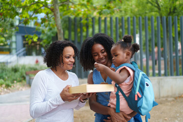 Grandmother, mother and daughter sharing a toys outdoors