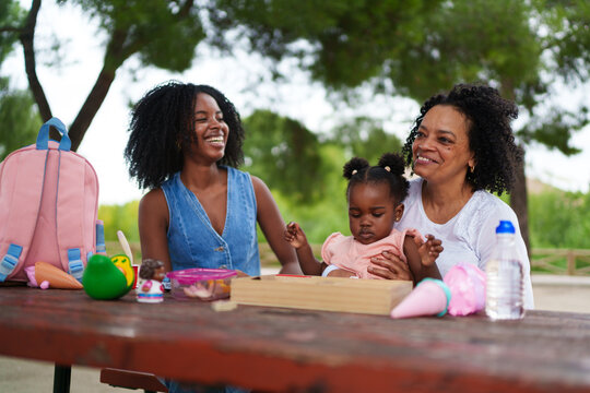 Happy family having fun outdoors at park picnic table