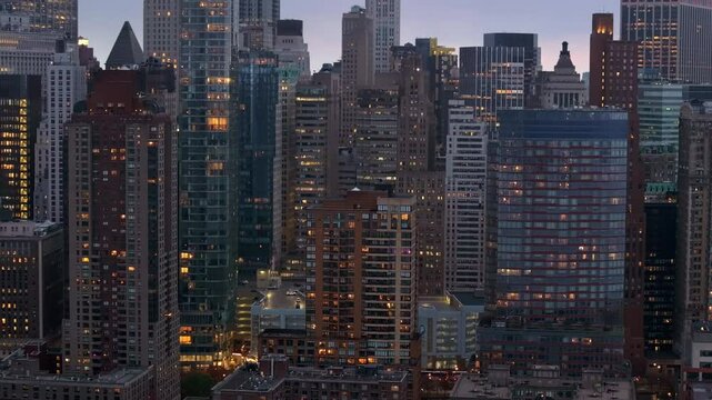 Aerial footage capturing luminous Manhattan skyline, revealing architectural diversity and urban landscape glowing during twilight hours