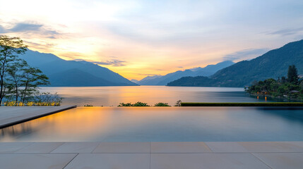 Fototapeta premium Infinity pool overlooking serene lake and mountains at sunset