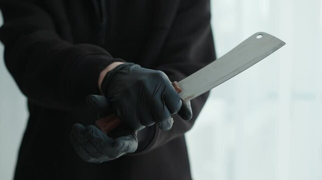 A killer in black rubber gloves holds a sharp ax in his hands.
A kitchen knife is in the hands of a man.
A criminal in black clothes and a sharp axe.
Knife, axe, weapon, criminal, revenge