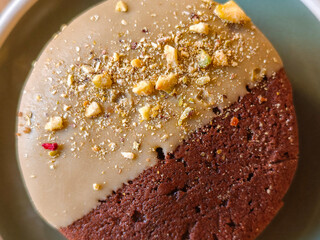 Close-up of Delicious chocolate cookies with hazelnuts, half glazed, on a light wooden table, top view. Space for text.