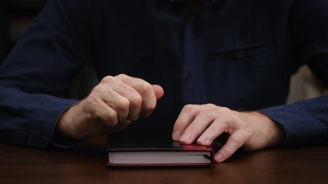 businessman sits at his desk, crumples piece paper and then abruptly throws it away with his finger. frustration, disappointment, unsuccessful attempt, impulsive act. close-up.
