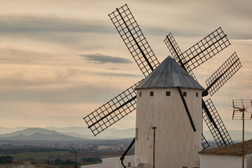 The iconic windmills of Campo de Criptana, famously linked to Don Quixote, standing against the vast Castilian landscape in Castilla-La Mancha, Spain