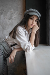 Portrait of a fashionable girl in plaid pants and a cap