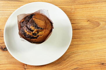 Chocolate cupcake on a plate, top view
