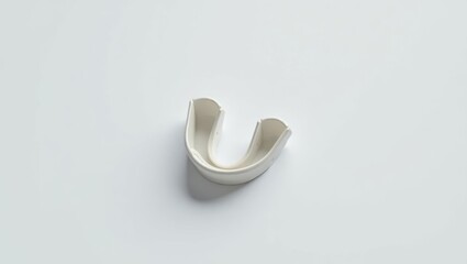 Anti Snoring Mouthpiece. White toothbrush holder is on white surface