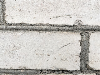 Rough texture of a concrete wall with cracks and irregularities. Gray tones, ideal for urban projects, backgrounds or industrial design. High quality, detail