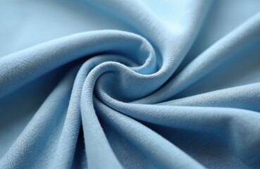 Close-up soft stretch denim fabric in pale blue wash. Lightly textured cotton jean material with curled wave. Textile background for clothing apparel, casual wear industry.