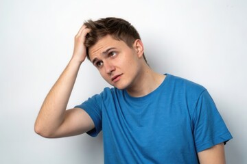 Fototapeta premium Pensive Young Man in Blue T-Shirt Reflecting on Thoughts with a Curious Expression