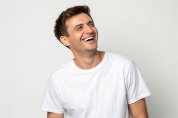 Obraz premium Joyful Young Man Laughing Against a Neutral Background: Capturing Happiness and Positivity