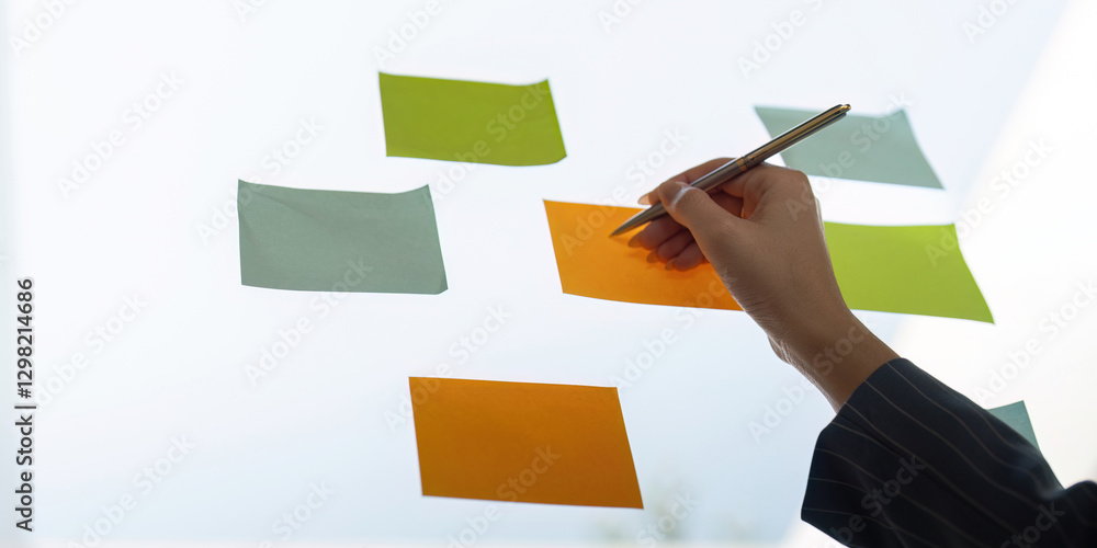 Poster colleagues sharing insights while arranging sticky notes for project planning and analysis.