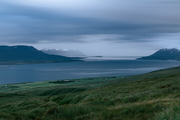 Obraz premium Scenic view of a fjord under dramatic cloudy sky