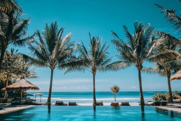 Fototapeta premium A beautiful tropical beach with palm trees and rocks on the left side, a blue sky in the background.