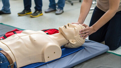 CPR training with medical mannequin demonstrating chest compressions and airway management