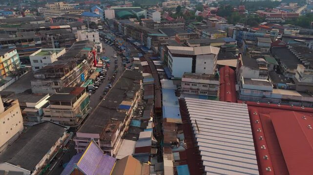 Aerial view of Maeklong Railway Market as a train moves through the narrow tracks among market stalls.