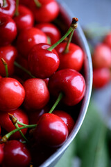 Freshly washed ripe juicy red cherries in steel colander close up. Natural food photography