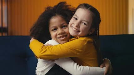 Portrait of two multiethnic little girls hugging and smiling, true friendship