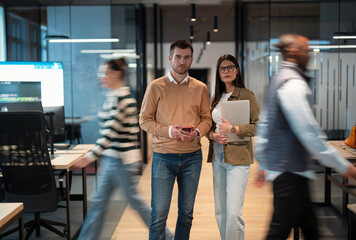 A diverse business team in a busy, modern office, collaborating on strategy and innovation....