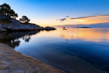 Serene sunset over calm sea, reflecting colors on tranquil water.